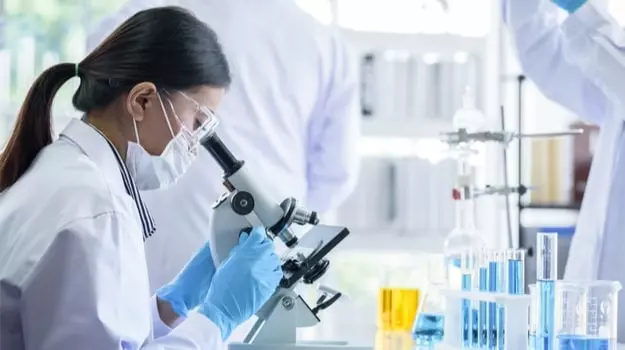 Scientists examining a formula under a microscope, representing the research behind JointBreX's joint-support ingredients